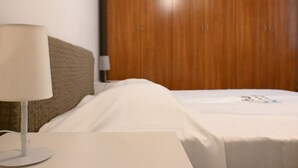 A hotel room with a bed, a bedside table with a lamp, and a wooden wardrobe. - A42 - Ancona, two-room apartment in the center (Ancona)