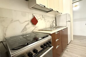 A kitchen with a stove, oven, and a refrigerator.