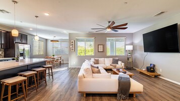A modern living space with a kitchen, dining area, and seating area.