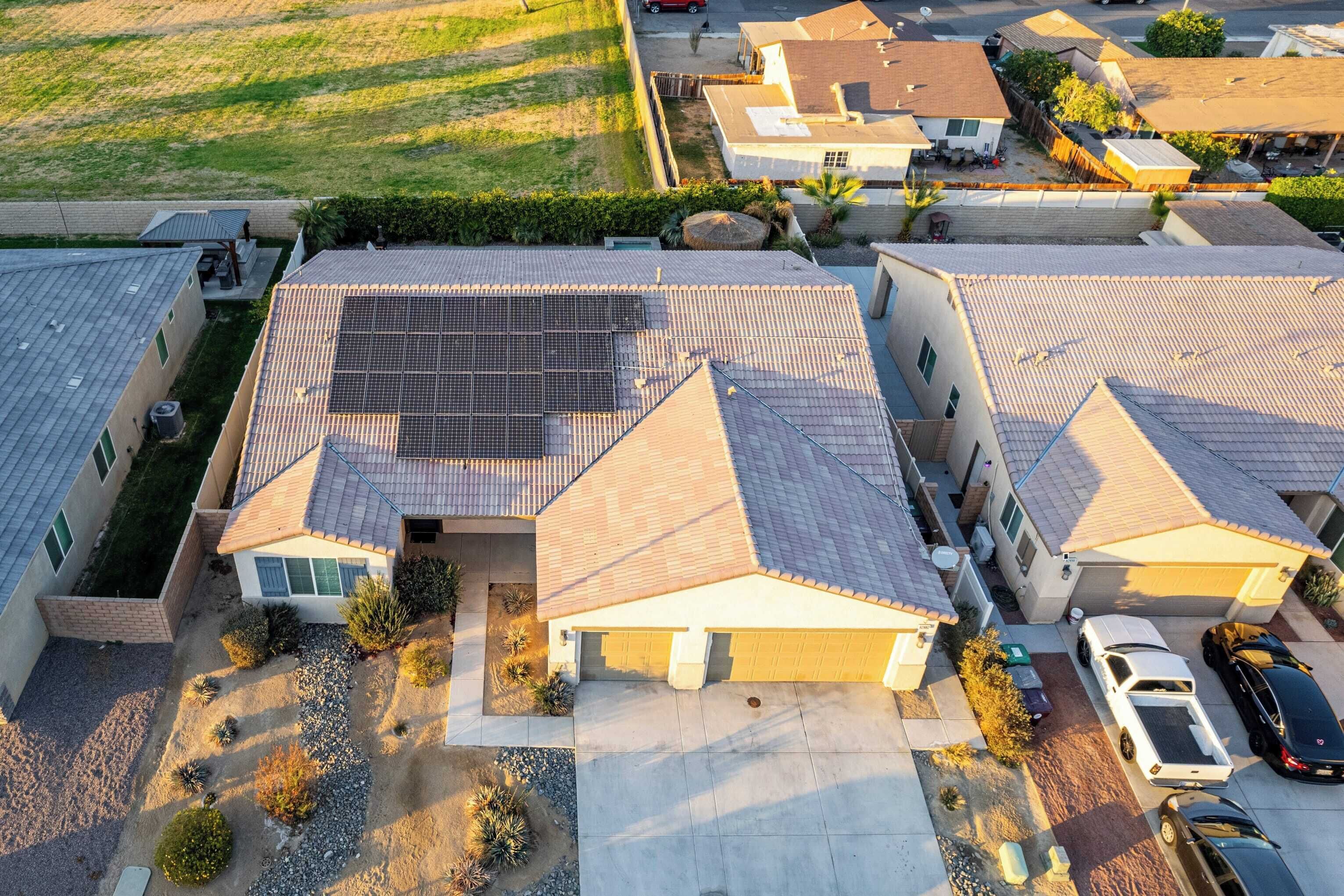 A residential area with houses featuring sloped roofs and solar panels.