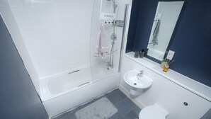 A modern bathroom with a glass-enclosed shower, a white sink, and a toilet. - Luxury 2 Bedroom Apartment in Birmingham Next to Utility Arena (Birmingham)