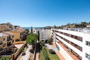 Zona residencial con edificios de varios pisos, cielo despejado y vista al mar.