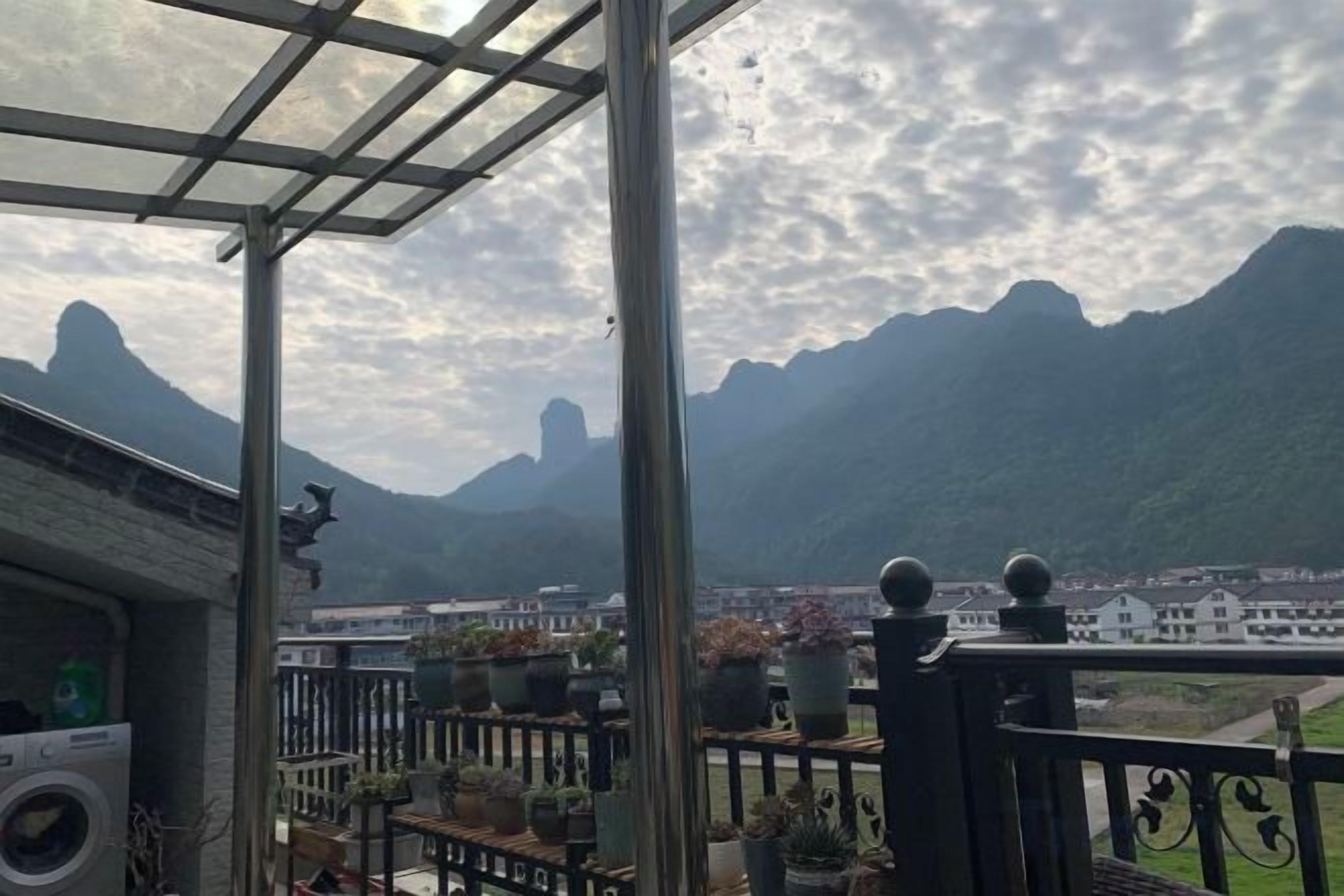 Un balcón con plantas en macetas y vistas a las montañas.