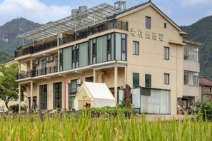 Un bâtiment à deux étages doté d’un balcon à l’étage supérieur, d’une zone couverte à l’avant et d’une enseigne avec des caractères chinois.