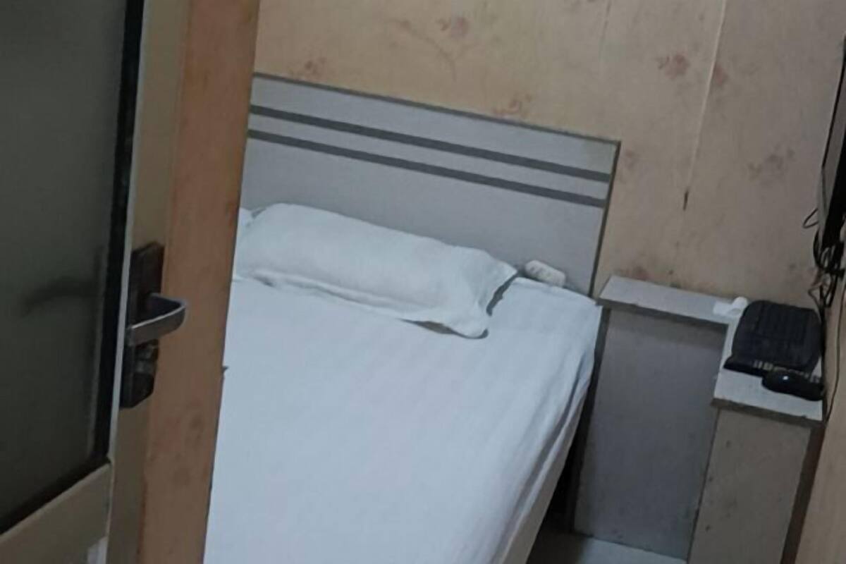 Une pièce avec un lit, un petit bureau et une porte.