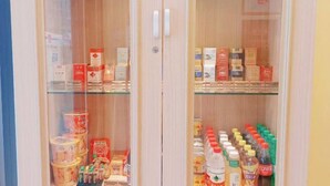 Een opslagruimte met planken vol diverse verpakte producten, waaronder dozen en flessen.