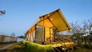 A modern, single-story building with a large glass window, a wooden deck, and a staircase leading to the entrance. - Liting Hotel (Yulong)