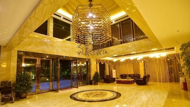 A spacious lobby with a high ceiling, a large chandelier, and a circular floor design. - Liting Hotel (Yulong)