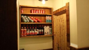 A wooden shelf unit with various beverages and snacks. - Qingdeng Mountain House (Lin'an Baima cliff scenic spot store) (Hangzhou)