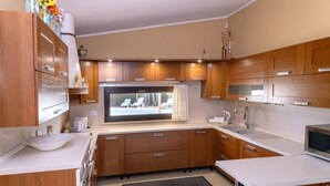 Une cuisine compacte avec des meubles en bois, une grande fenêtre et un four à micro-ondes encastré.