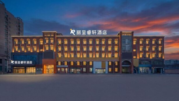 Ein Hotel mit einer modernen Fassade, mehreren Etagen und beleuchteten Fenstern.