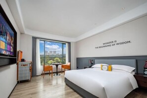 Una habitación de hotel moderna con una cama grande, un escritorio, una silla, un televisor y un ventanal con vista a la ciudad.