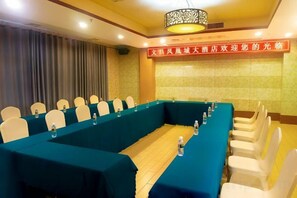 A conference room with a long table, chairs, and a banner. - Fenghuangcheng Hotel (Wenchang)