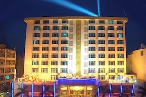Un hotel a più piani con un atrio centrale e un'ampia entrata illuminata.