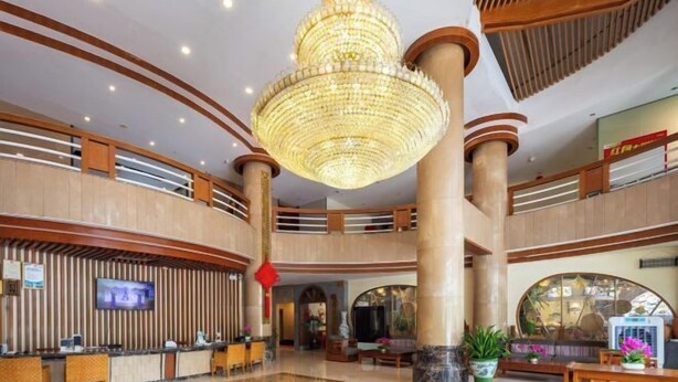 A spacious lobby with a grand chandelier, multiple seating areas, and a reception desk. - Fenghuangcheng Hotel (Wenchang)