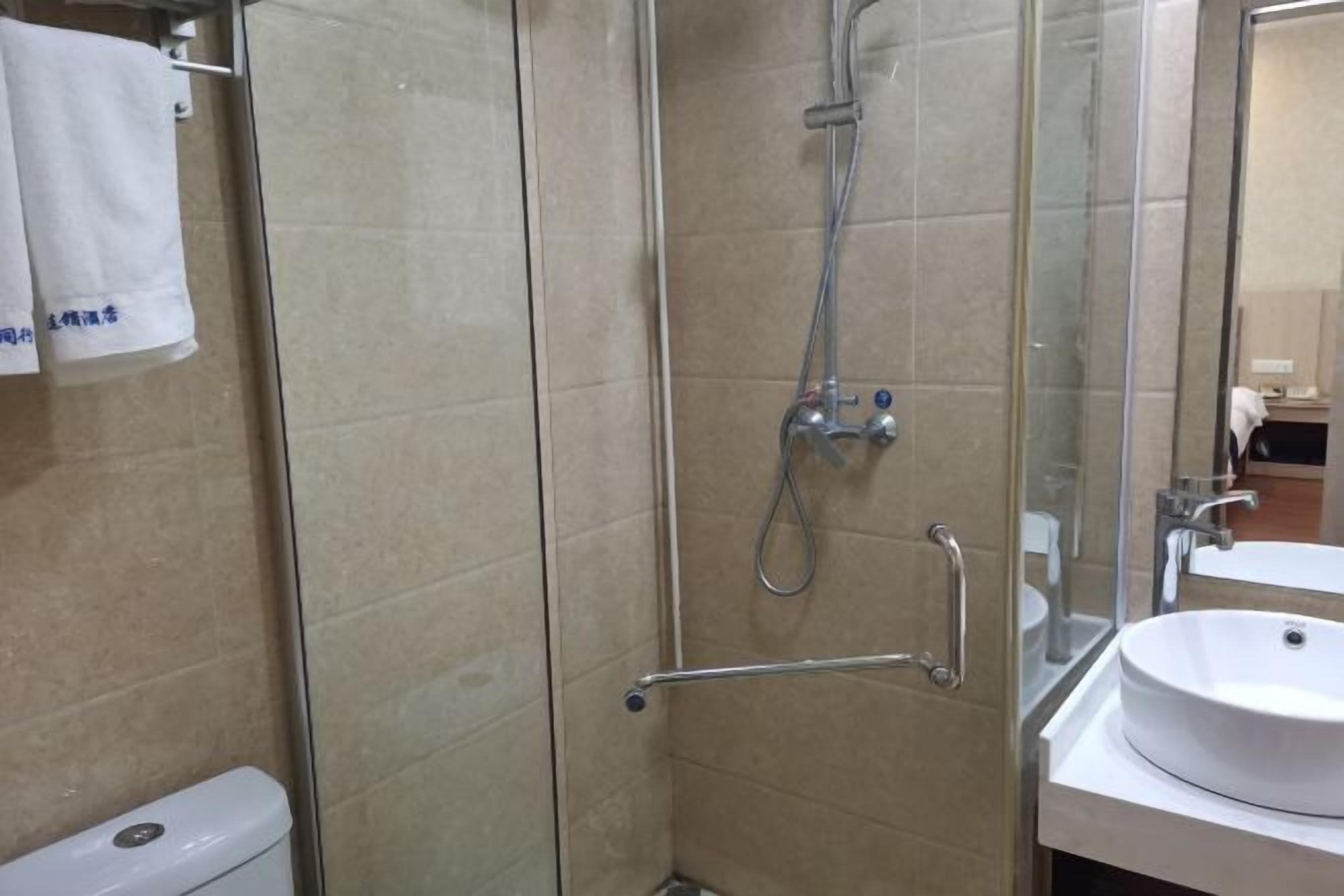 A modern bathroom with a glass shower enclosure, a white sink, and a toilet.