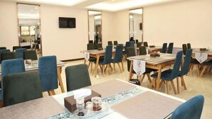 Un salón de conferencias con varias mesas y sillas, equipado con tarjetas de identificación y preparación para una comida.