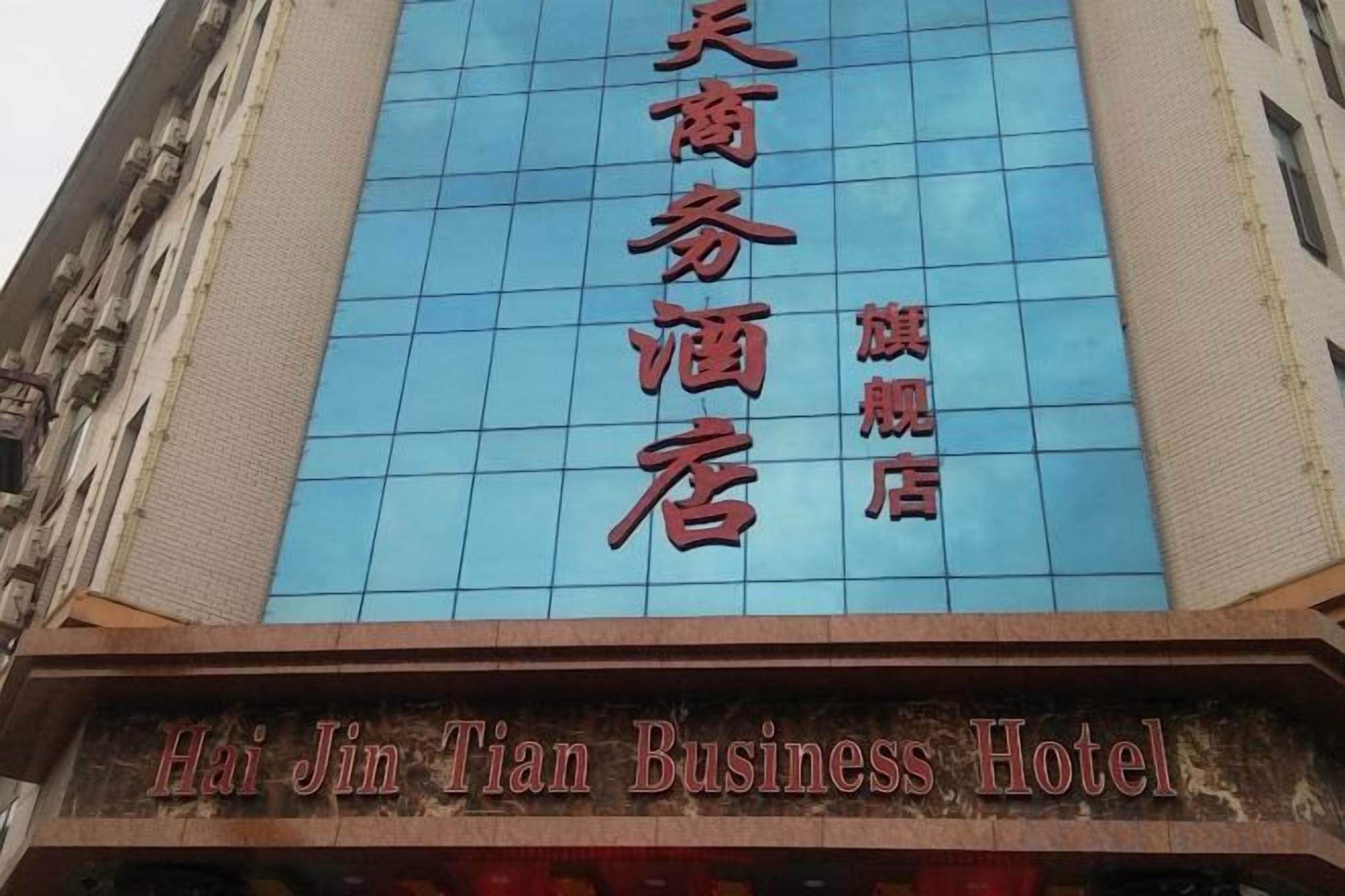 A hotel sign with Chinese characters and English text 'Hai Jin Tian Business Hotel'.