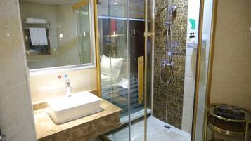 A modern bathroom with a glass-enclosed shower, a sink with a marble countertop, and a mirror.