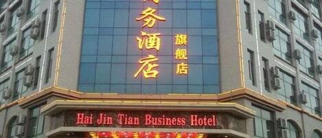 Un hotel con un letrero grande en caracteres chinos y uno más pequeño en inglés.