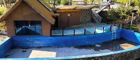 Un modelo de barco con una estructura de casa, un pequeño muelle y un muro de piedra.