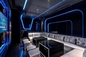 A modern lounge area with a sofa, tables, and a TV screen. - Diebu Yiguowa Hotel (Diebu)