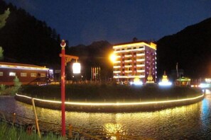 A building with multiple floors and a waterfront view. - Diebu Yiguowa Hotel (Diebu)
