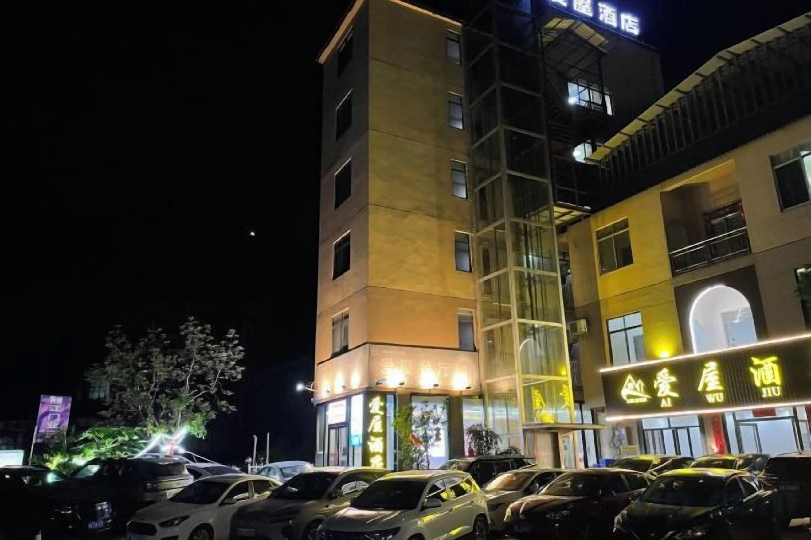 A multi-story hotel with a parking lot in front.