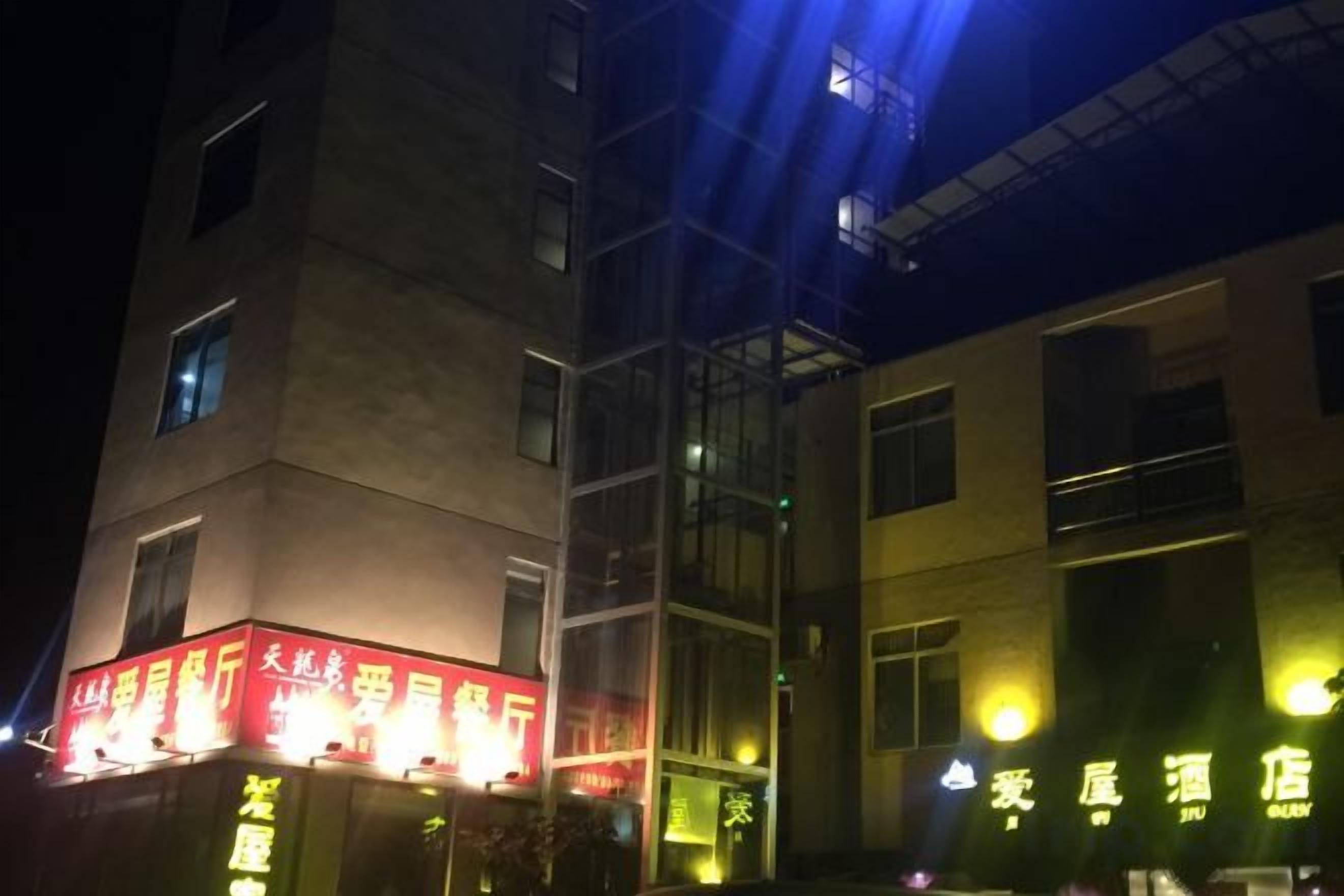 A building with illuminated signage, a visible staircase, and a clear sky.