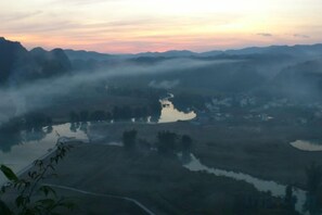 A misty landscape with a river and surrounding hills. - Aiwu Inn Daxin County Detian Waterfall (Daxin)