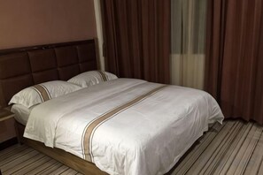 A hotel room with a bed, a nightstand, and a window with curtains. - Aiwu Inn Daxin County Detian Waterfall (Daxin)