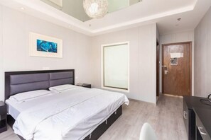 A modern bedroom with a large bed, a bedside table, a nightstand, a window, and a door. - Haopai Hotel (Shanghai)