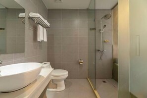 Une salle de bain moderne avec un grand lavabo, des toilettes et une douche à parois de verre.