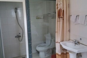 A bathroom with a shower, toilet, and sink.