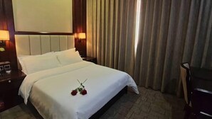 A hotel room with a bed, a nightstand, a lamp, and a large window with curtains. - YinXiang changchun (Huixian)