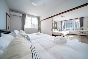 A hotel room with two beds, a large window, a balcony, and a view of the city. - GRAND SOLEIL (Sapporo)