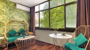 A room with a large window, a round table, two chairs, and a small sofa. - Xianju Nanxingyuan Boutique Hotel (Wuyue Plaza) (Xianju)