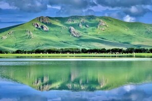 A calm lake with a mountain in the background. - Ergun Heishantou Jixiangyuan Homestay (Ergun)