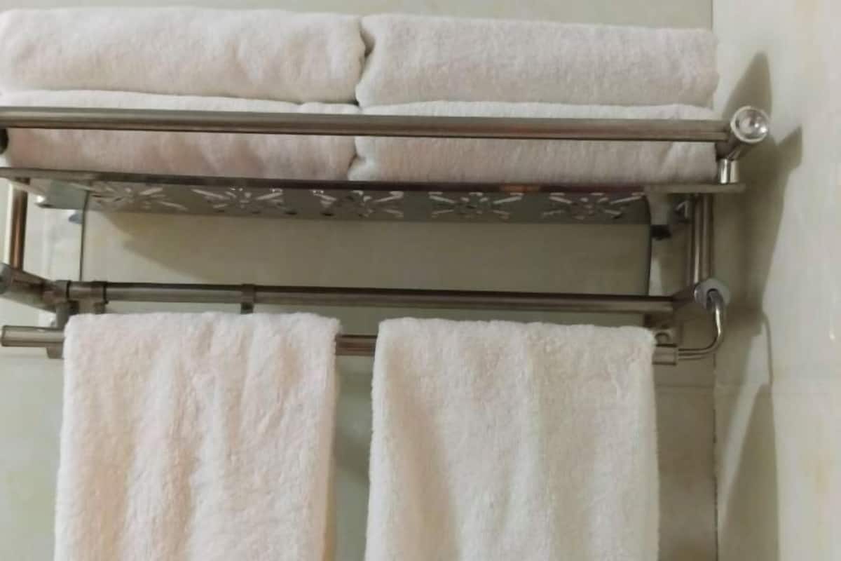 Un baño con un perchero que sostiene tres toallas.