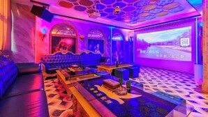 A room with a large screen displaying text, a sofa, a coffee table, and a patterned floor. - Foshan Yuefeng High-altitude Garden Panorama Hotel (Jiujiangzhen Xinji Plaza) (Foshan)