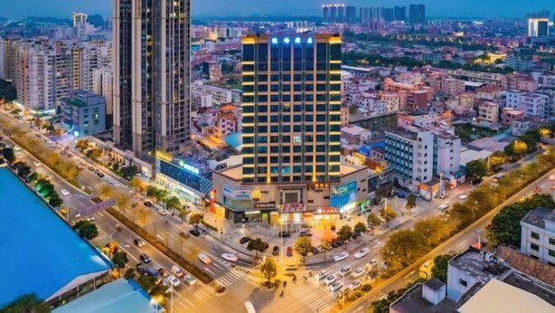A high-rise hotel with multiple floors, a central courtyard, and a busy street in the background. - Foshan Yuefeng High-altitude Garden Panorama Hotel (Jiujiangzhen Xinji Plaza) (Foshan)