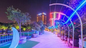 A pathway lined with illuminated arches and a crescent moon sculpture, leading towards a building with illuminated windows. - Foshan Yuefeng High-altitude Garden Panorama Hotel (Jiujiangzhen Xinji Plaza) (Foshan)