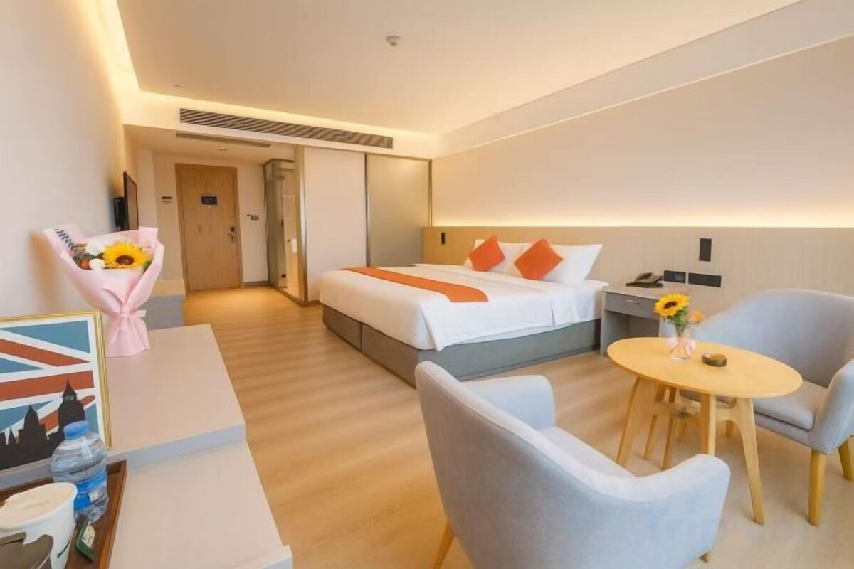 Une chambre d’hôtel avec un lit, un bureau, une chaise et une petite table.
