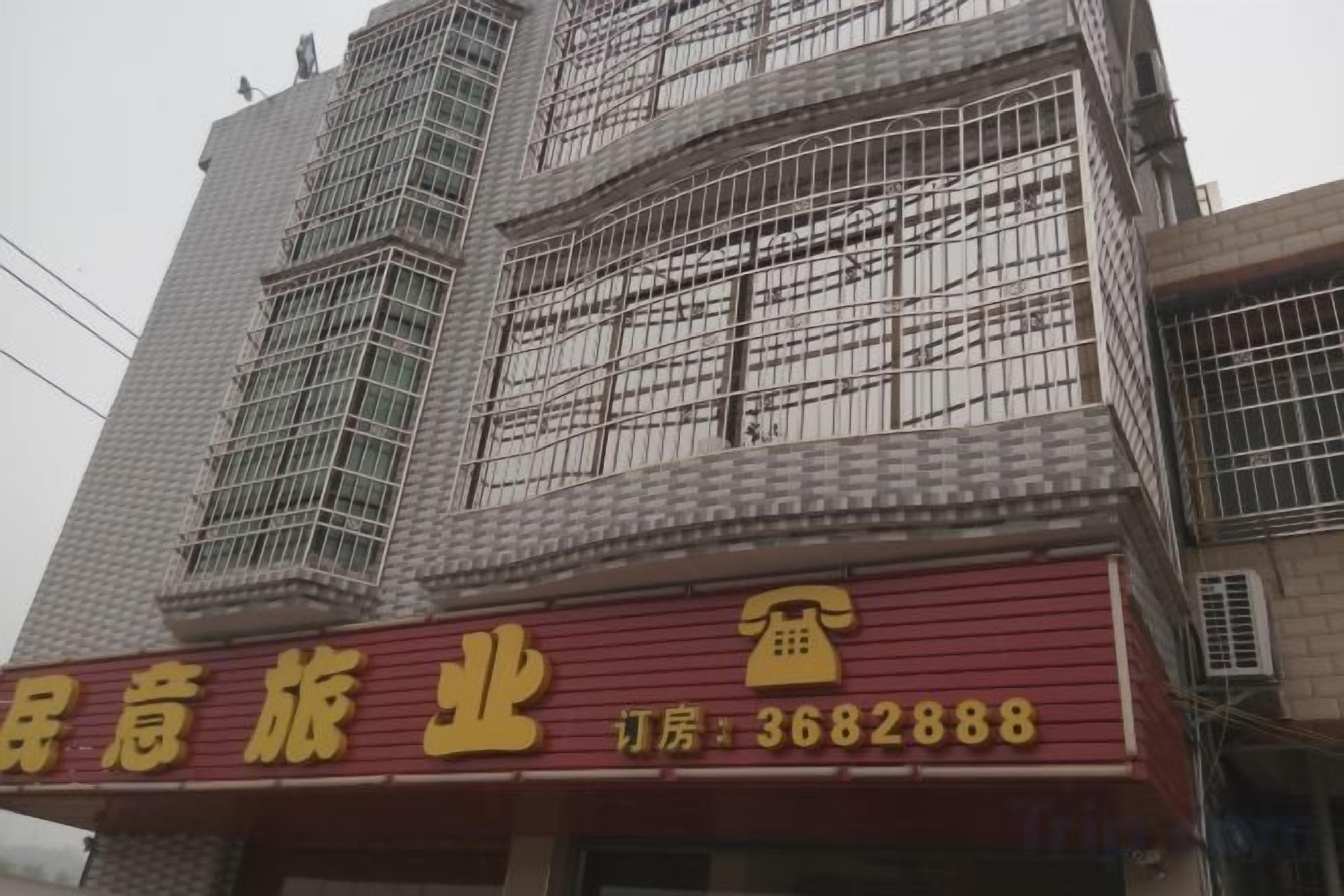 A building with a red signboard and scaffolding.