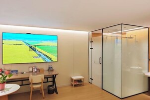 Un espacio de oficina moderno con un televisor de pantalla plana grande montado en la pared, mostrando un paisaje.