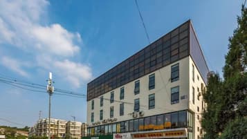 En byggnad med flera våningar och en modern arkitektonisk design, med ett platt tak och stora fönster.