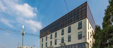 A multi-story building with a modern architectural design, featuring a flat roof and large windows.