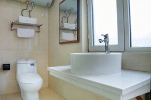 Une salle de bain équipée de toilettes, d’un lavabo et d’un porte-serviettes.