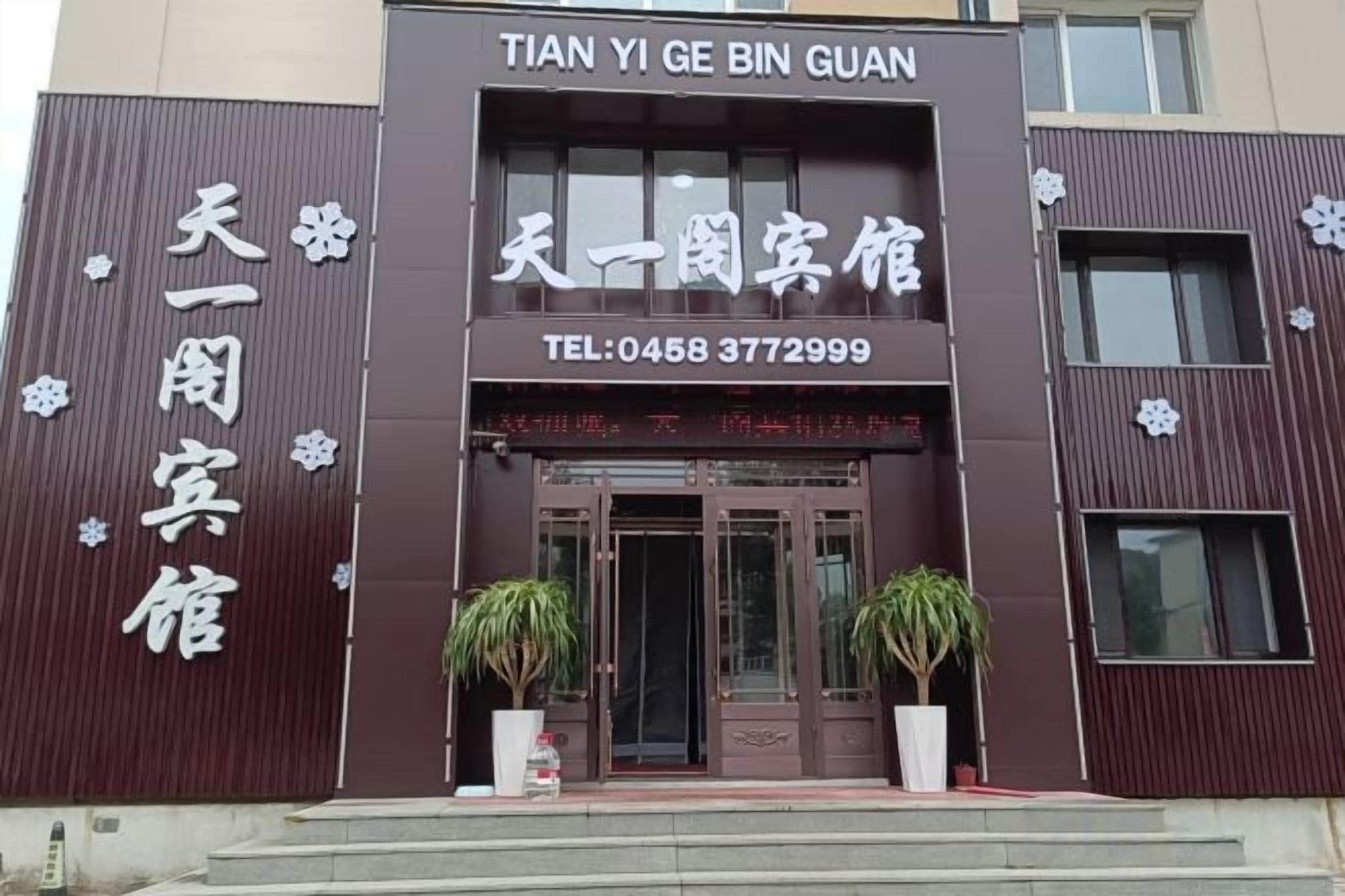 A hotel entrance with a sign reading 'TIAN YI GE BIN GUAN' and a telephone number.