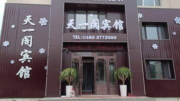 A hotel entrance with a sign reading 'TIAN YI GE BIN GUAN' and a telephone number.